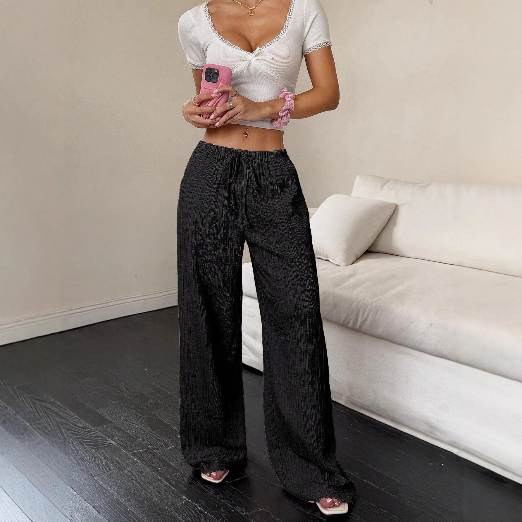 Women's wide-leg black trousers with a lace-up detail on the mid-rise waistband.