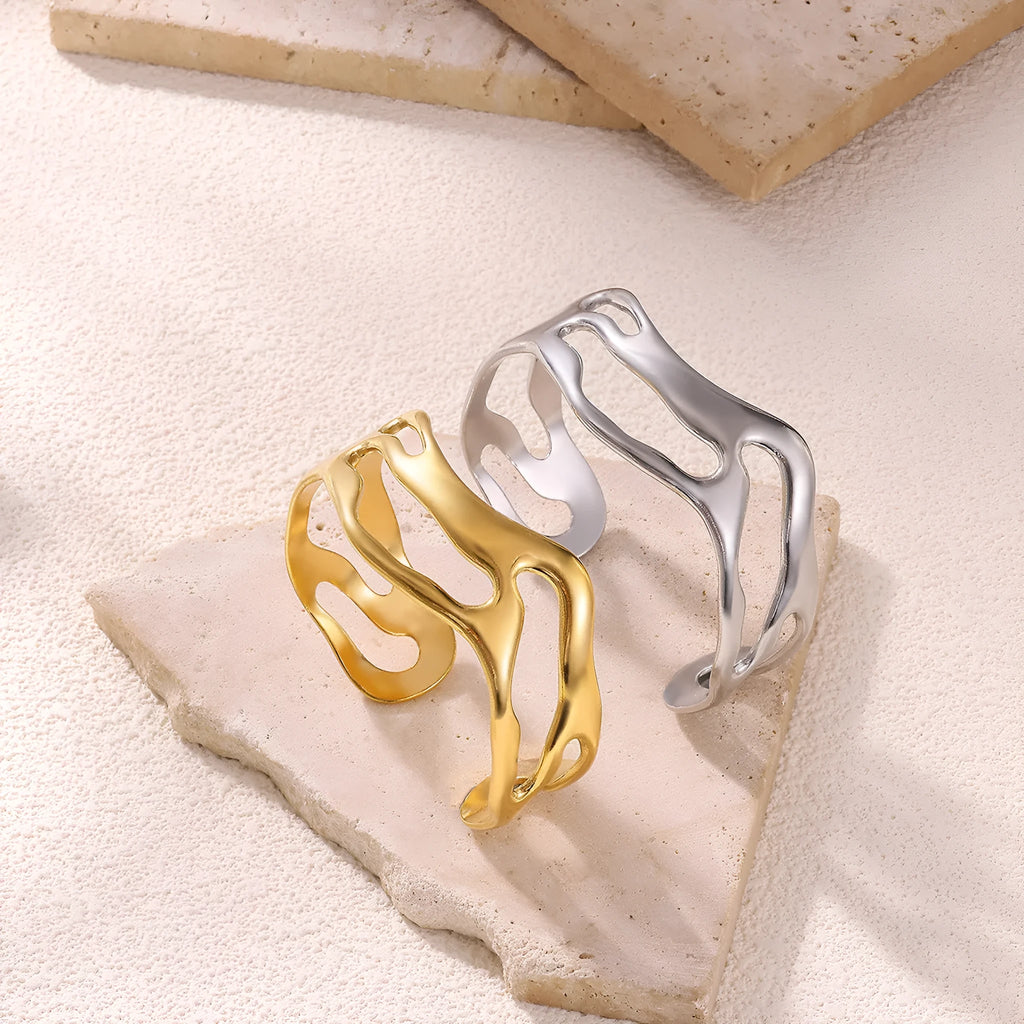 Simple irregular stainless steel gold-plated bracelet in silver finish on plain background