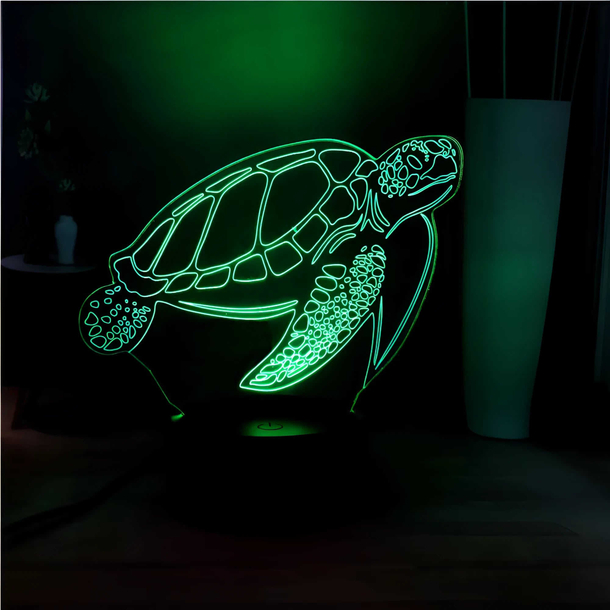 3D green turtle shaped LED night light glowing with multi-colours on a wooden table.