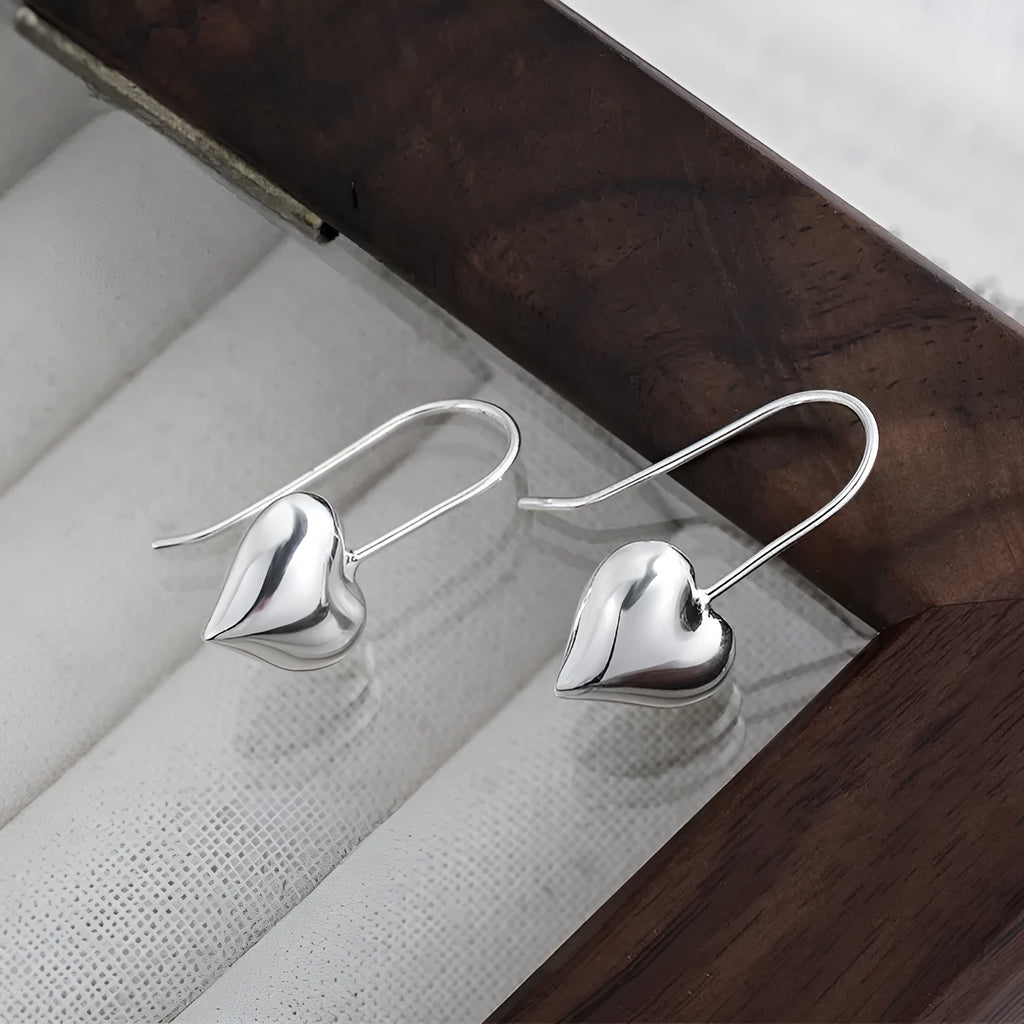 Silver-coloured heart-shaped earrings with three-dimensional glossy design and Korean style aesthetics