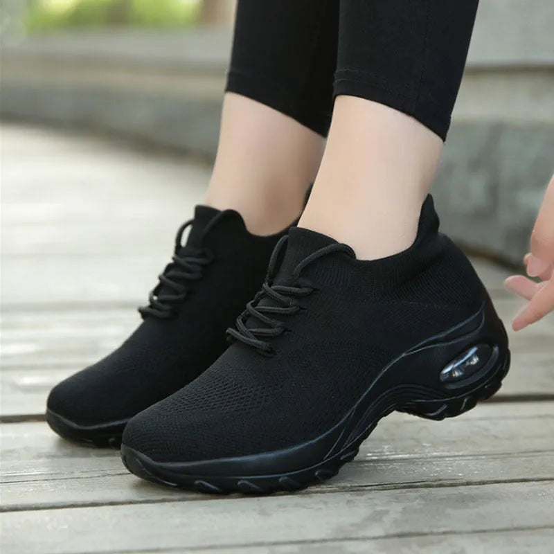 Women's flying knit platform sneakers in black with round toe and waterproof sole