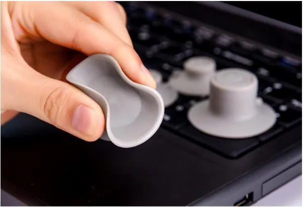 Four grey plastic laptop cooling pads: two large and two small, on a flat surface.