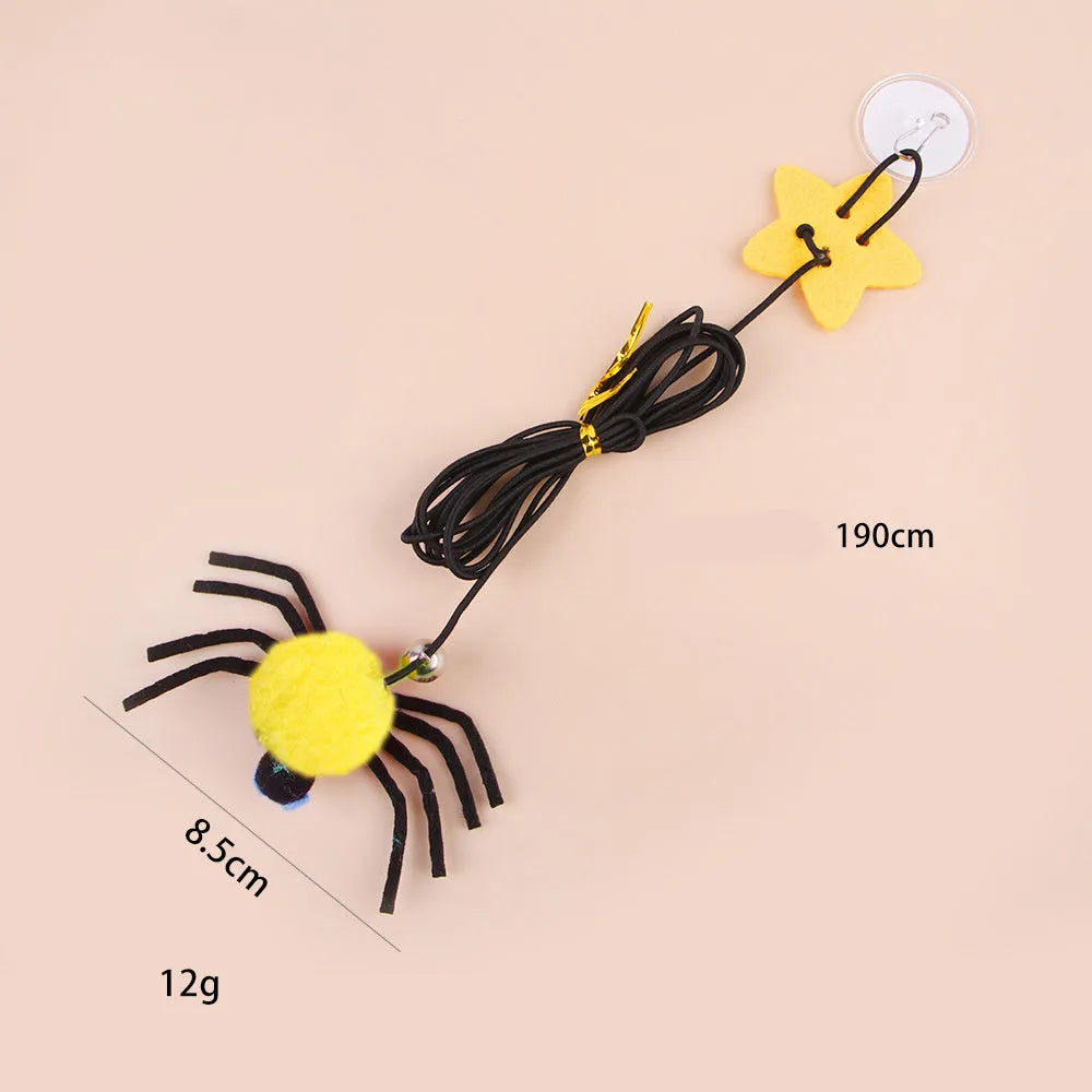 Red and yellow hanging cat toy with elastic rope, feather, bell, and spider elements for door mounting