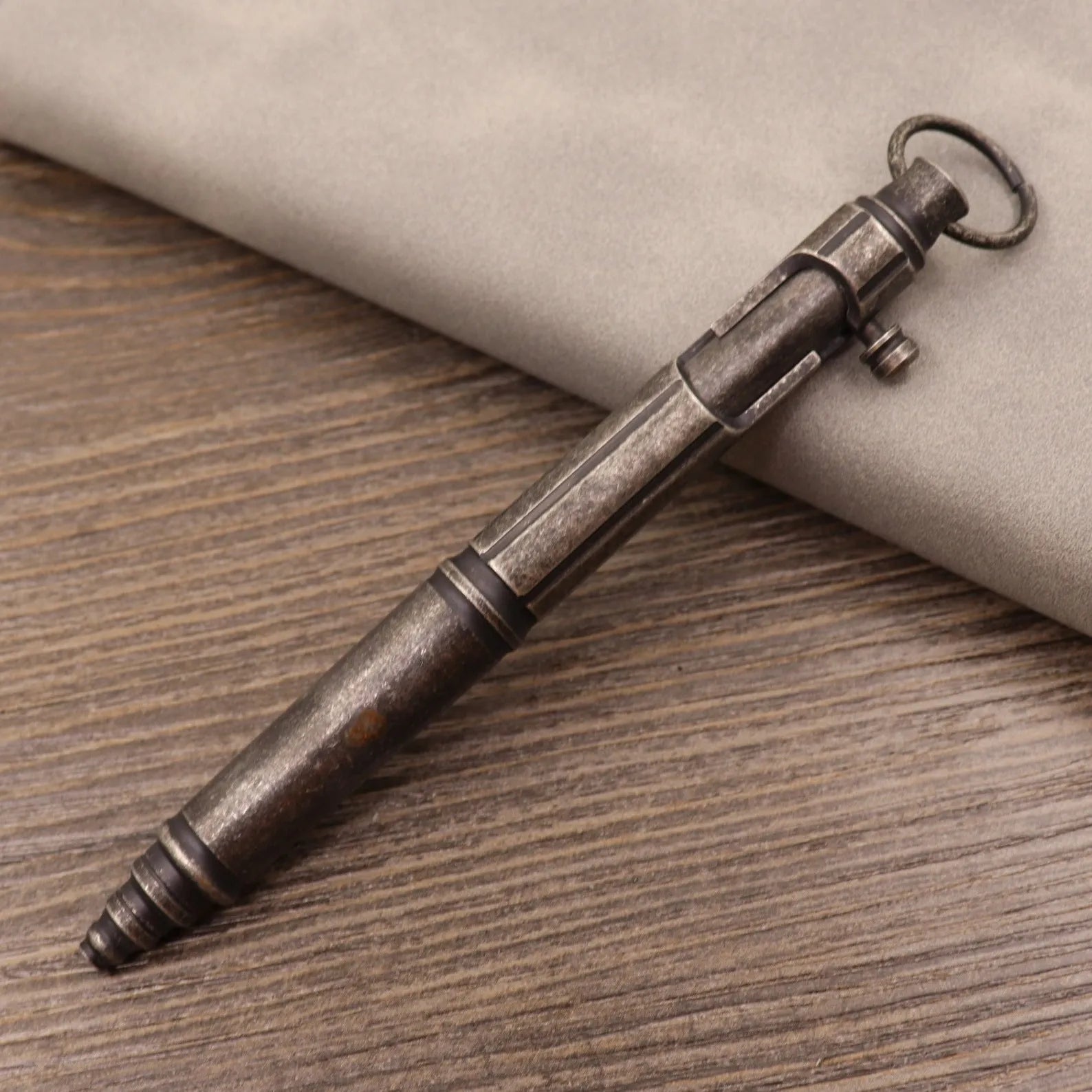 Brass bolt-action tactical pen in a retro copper finish, showing press mechanism and textured barrel.