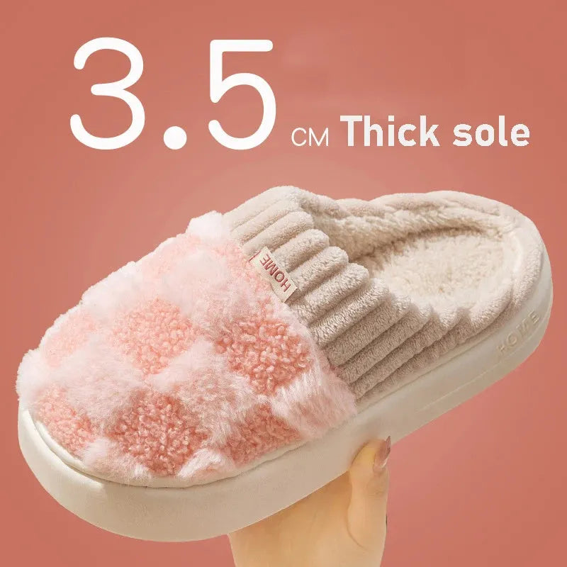 Women's plaid patterned coral velvet indoor slippers with a thick soft sole on a wooden floor.