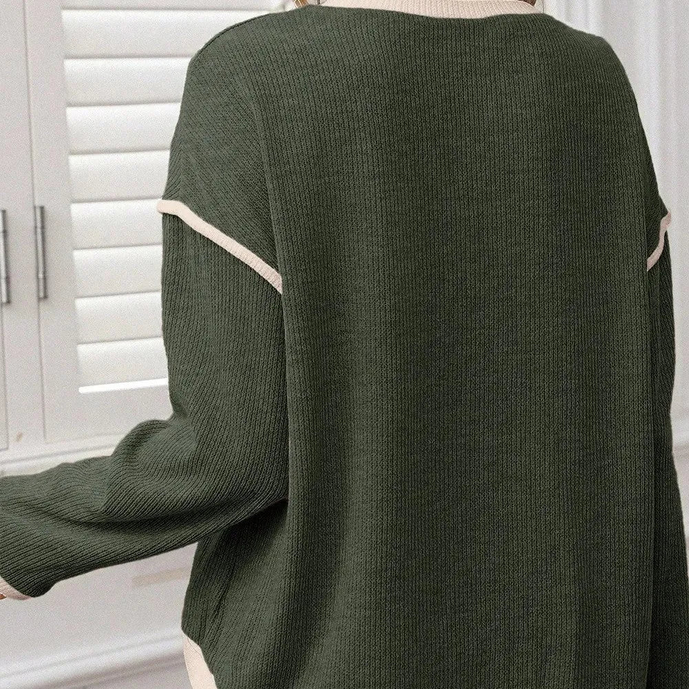 Woman wearing a green four leaf clover pattern loose knit top with drop shoulders and contrast trim