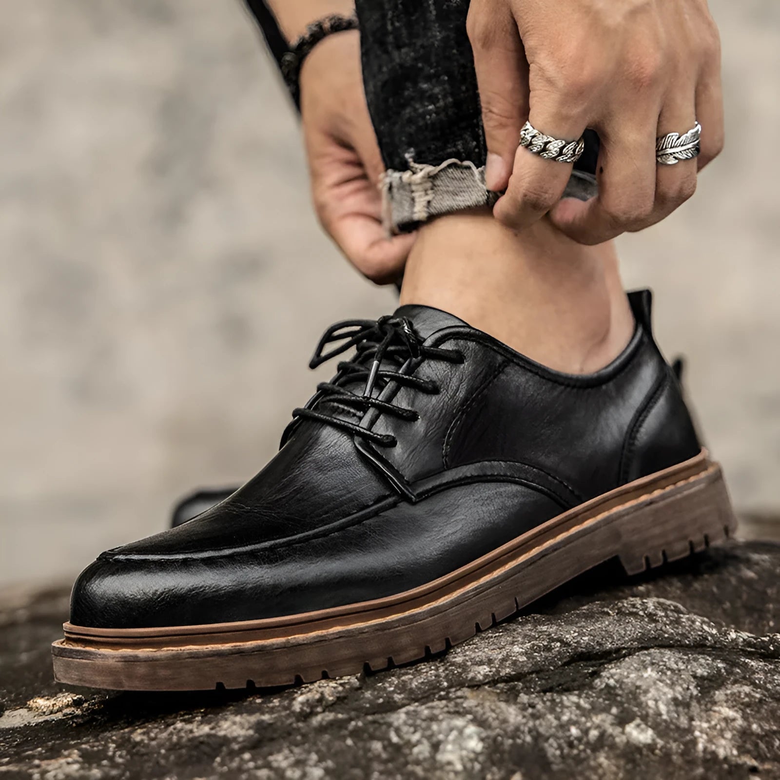 Men's black casual leather shoes with sewing line details and a round toe on a flat rubber sole.