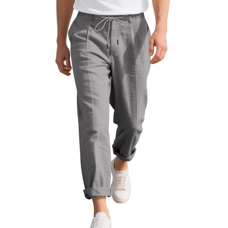 Men's light khaki linen casual trousers with a straight leg and drawstring waistband laid flat.
