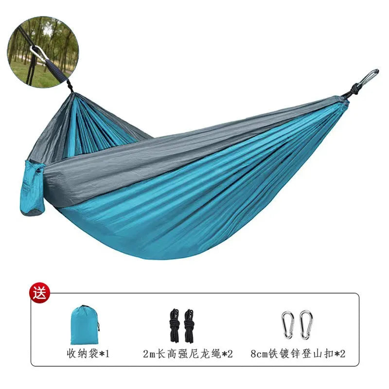 Blue nylon parachute cloth outdoor camping hammock shown in a natural setting.