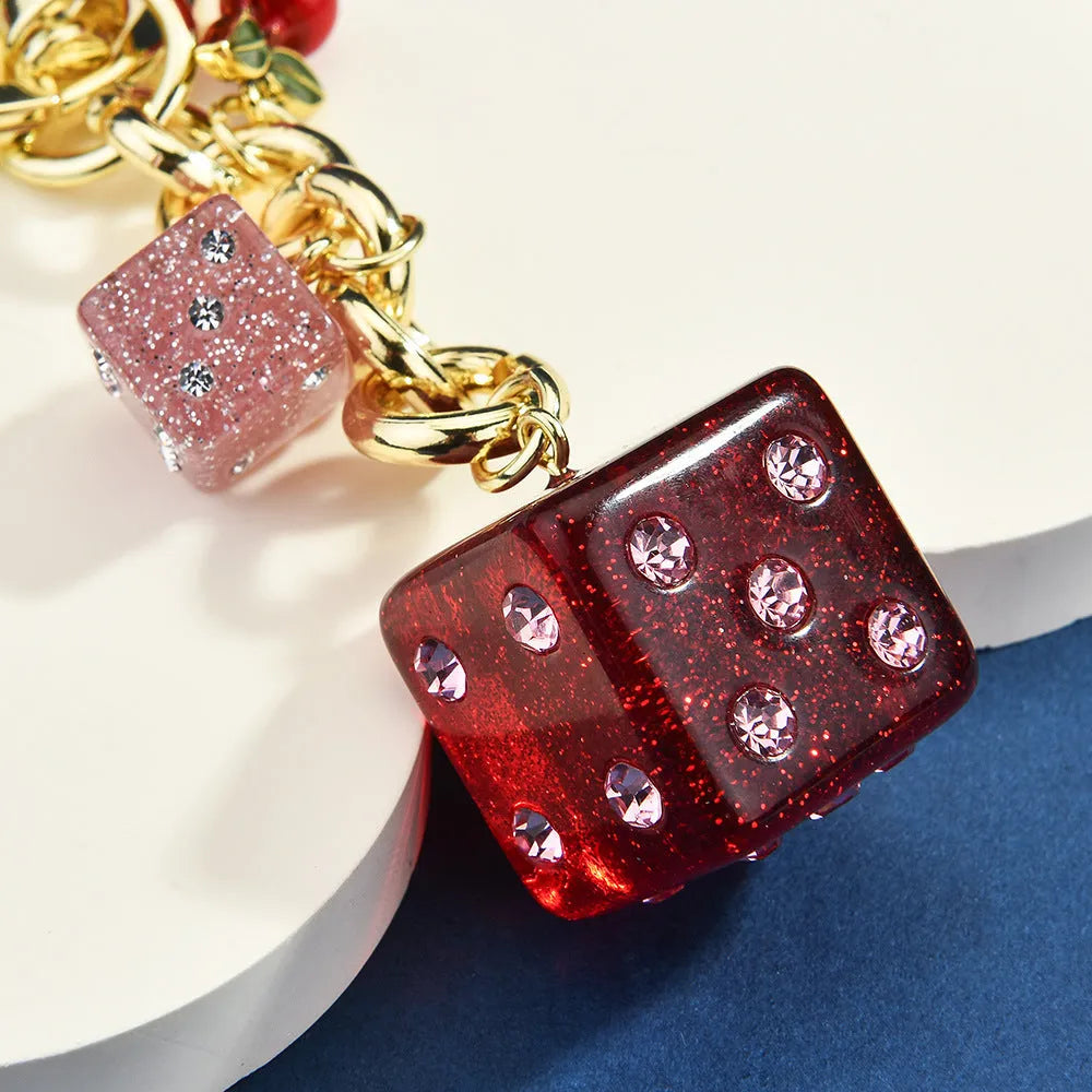 Square metal keychain pendant with a cerise two-tone dice pattern.