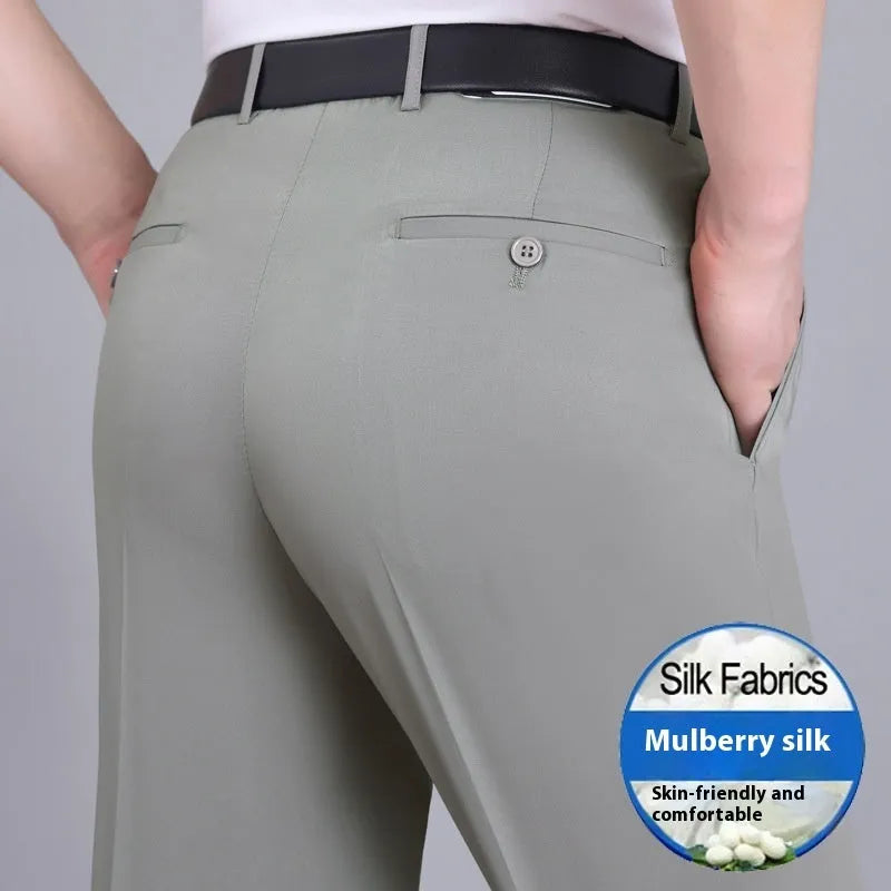 Man wearing dark blue straight-leg suit trousers with a high waist, made from a mulberry silk blend fabric.