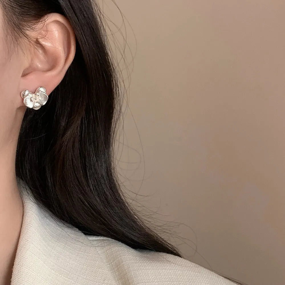 Retro floral fashion earrings in gold or silver colour with petal detailing on copper base.