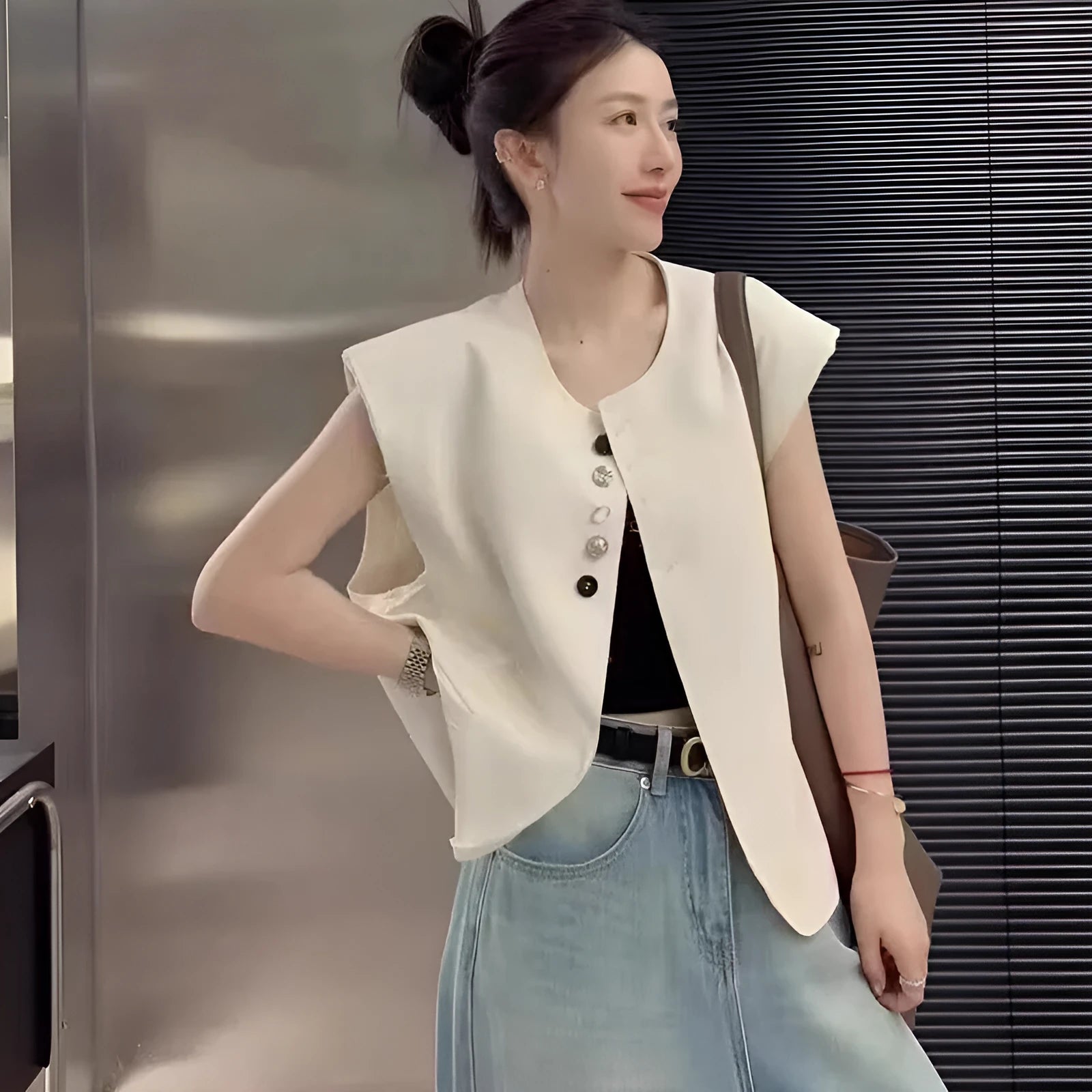 Women's loose-fit short-length polyester vest in milky white colour with front pockets.