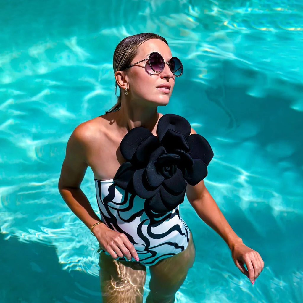 Women's one-piece swimsuit with three-dimensional floral pattern in black and blue colour options.
