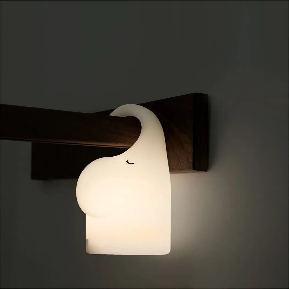 DOMI Elephant-shaped silicone night light with soft white glow on a bedside table