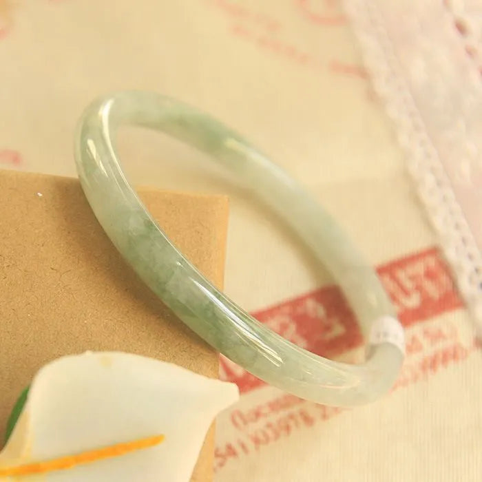 Green jade waxy geometric bracelet with unisex Chinese style design on a wrist.