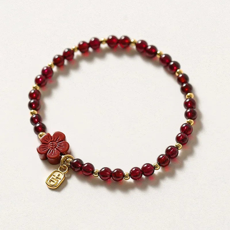 Women's geometric braided rope bracelet with freshwater pearls, amethyst, pomegranate, and red beads.