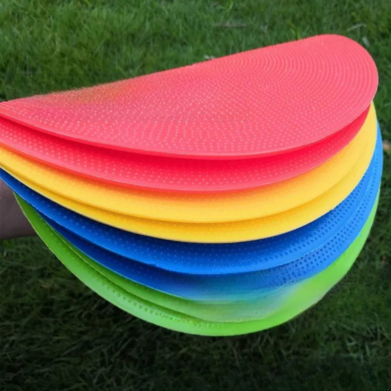 Yellow TPE football training target disc on grass, 23cm diameter flat landmark pad