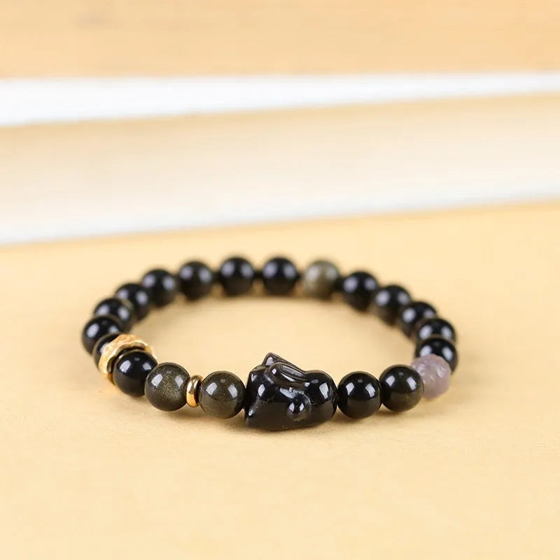 Handmade lying rabbit obsidian bracelet in brass with grey agate, showing national style design.