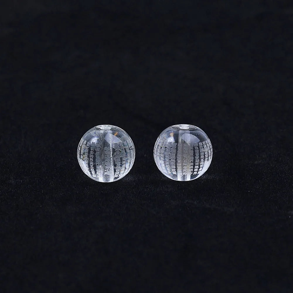 Ten round 10mm coloured glaze beads with Buddhist mantra text on a white background.