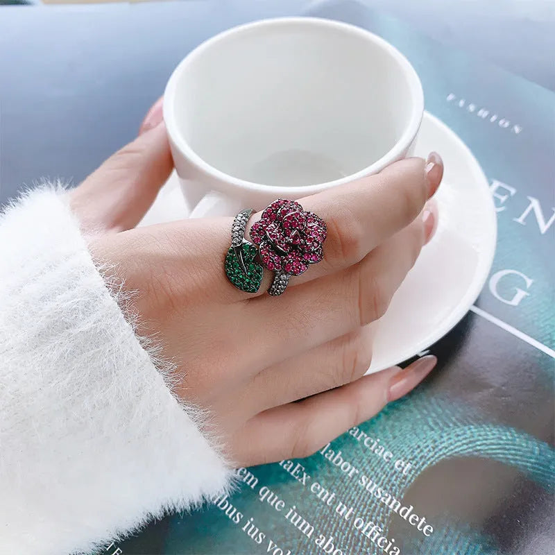 Black gold plated geometric floral ring with a red simulated corundum stone for women.