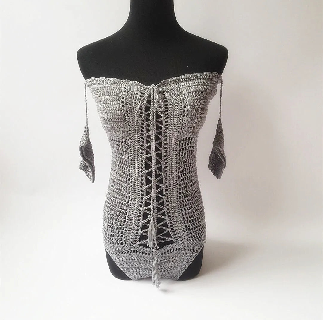 Women's off-shoulder one-piece swimsuit on a mannequin, shown in a light colour.
