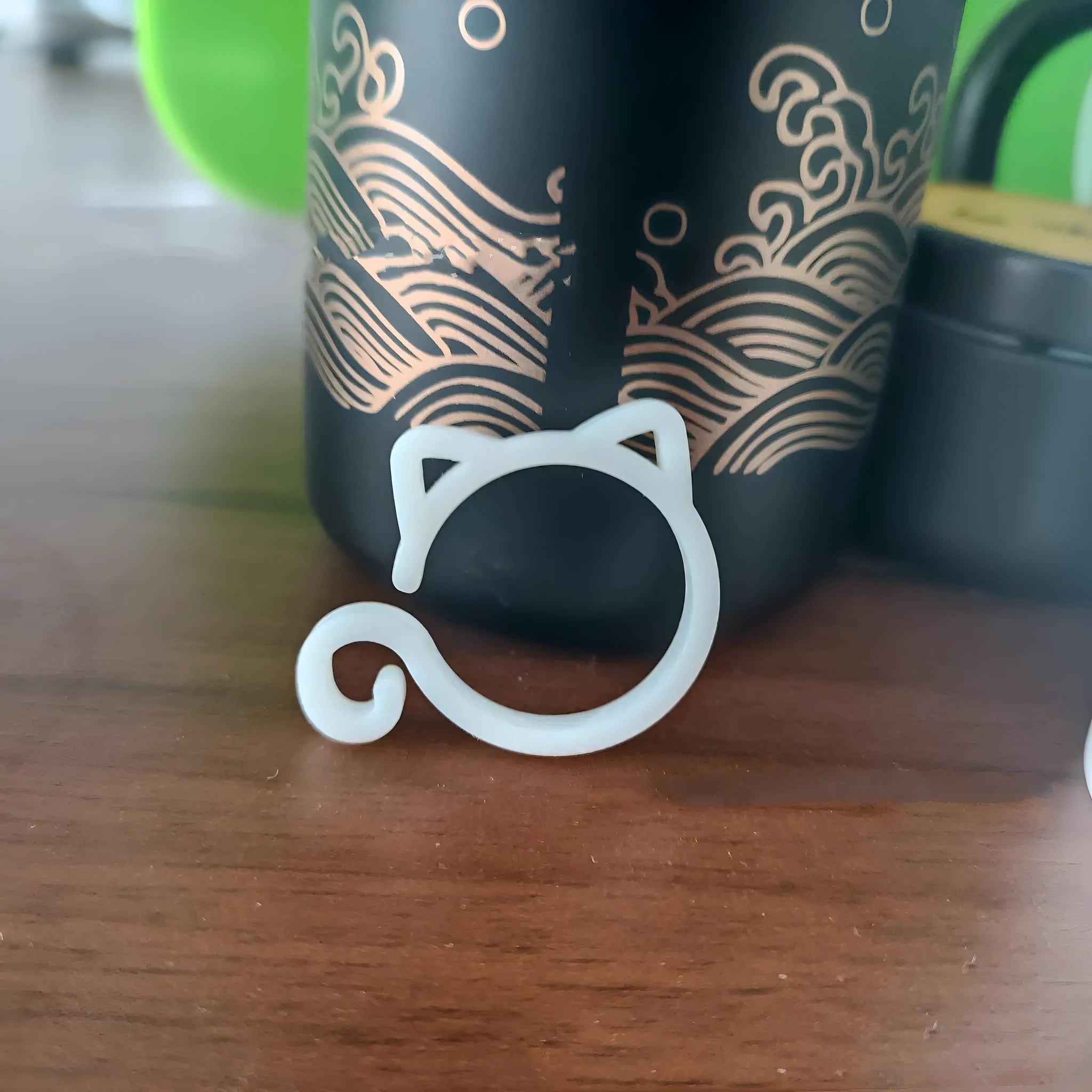 Cat-shaped plastic plant clip in garden with colourful options shown