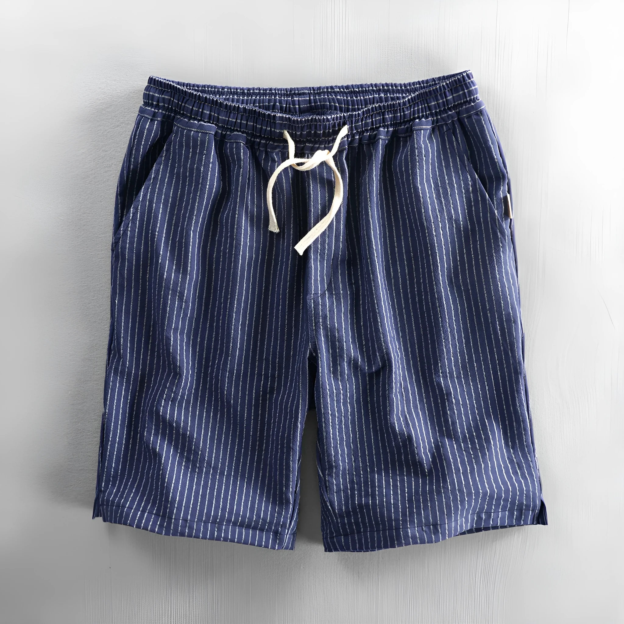 Man wearing striped light blue cotton casual shorts with a mid waist and loose straight fit.
