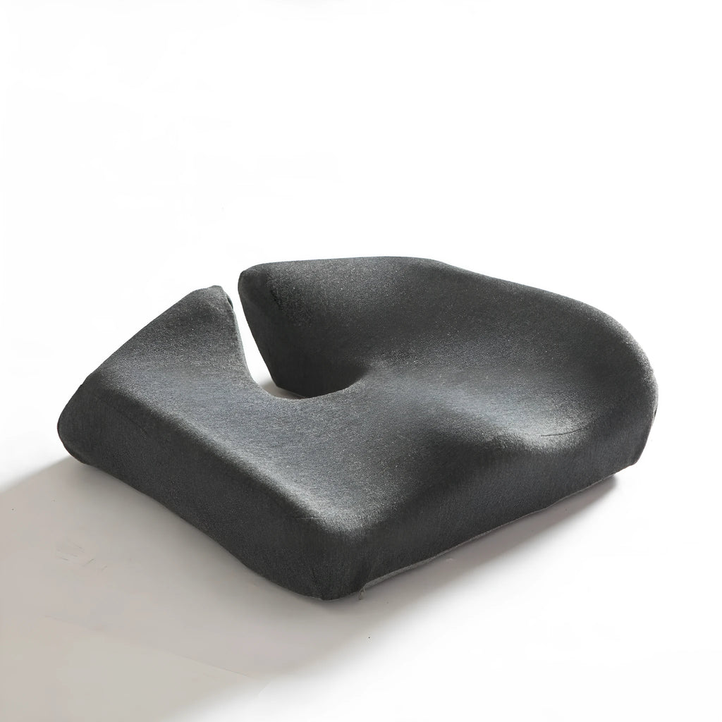 Dark grey memory foam office chair cushion for waist support, shown on a desk chair.