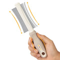 White double-sided pet grooming brush with deshedding and comb functions, curved design, ergonomic handle