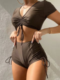 Women's two-piece swimsuit with lace-up front and bow detail in dark green.