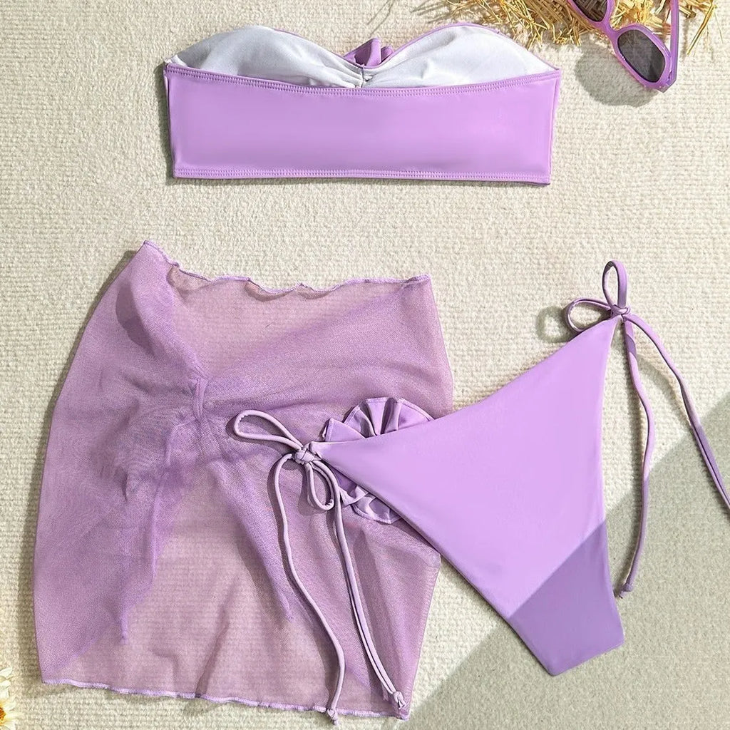 Blue women's tube top swimsuit with big 3D flower tie, matching bottoms, and skirt
