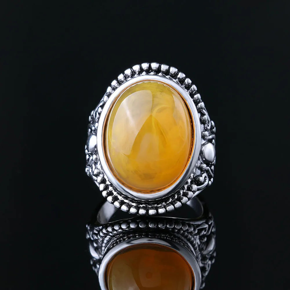 Close-up of a geometric retro ring in antique silver amber with a beeswax fluorescent finish.