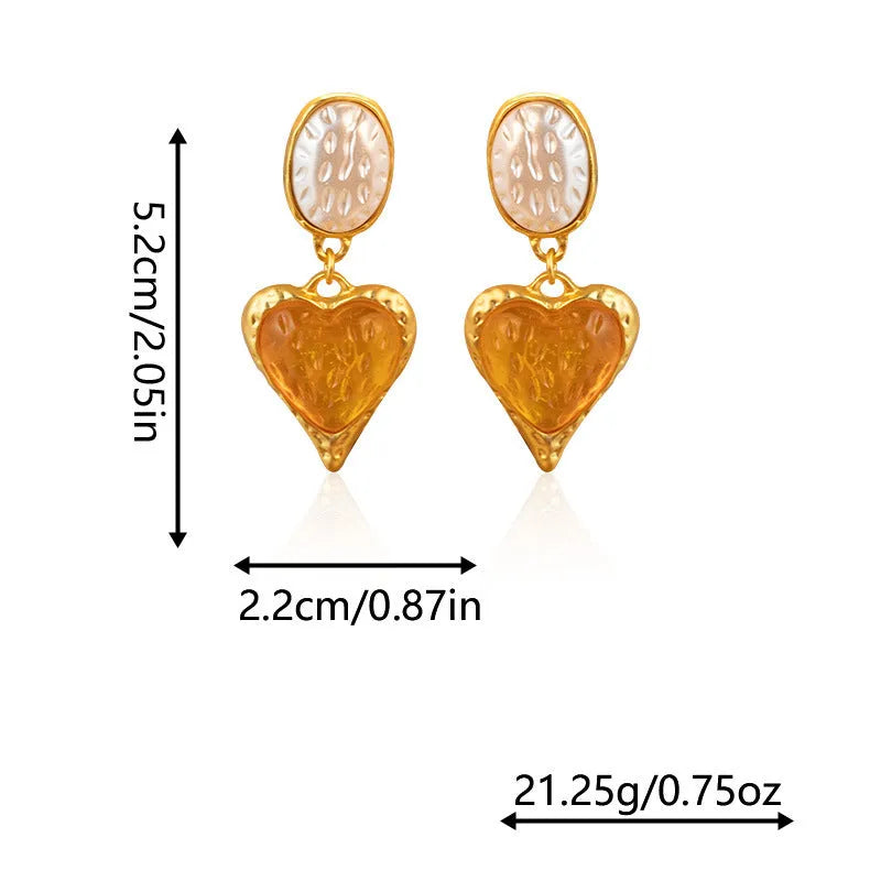 A pair of alloy silver needle pleated oval love heart stud earrings on a purple background.