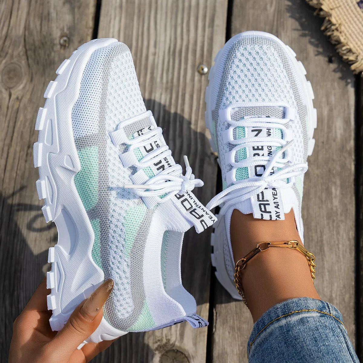 Women's Flyknit mesh sneakers in grey and white colour with flat rubber sole and lace-up front.