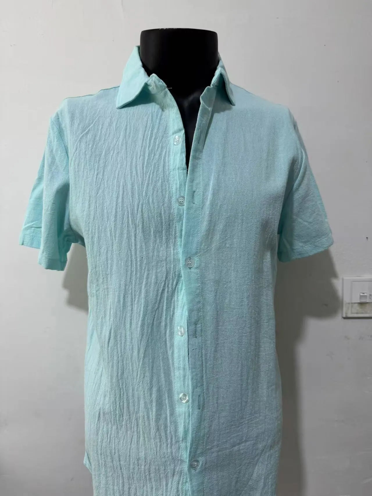 Men's loose fit short sleeve linen shirt in apricot colour on a hanger