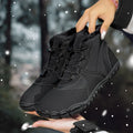 Black waterproof snow boots with lace-up front, fleece lining, and rubber sole on a winter background