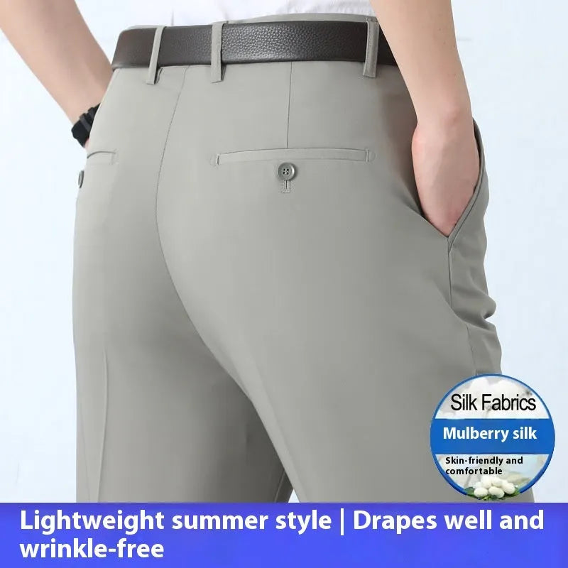 Man wearing dark blue straight-leg suit trousers with a high waist, made from a mulberry silk blend fabric.