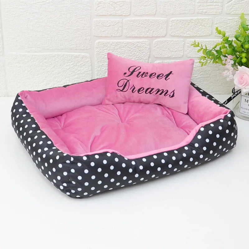 Polka dot printed square dog bed with raised bolsters and a matching embroidered pillow.