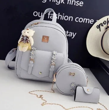 Women's three-piece PU leather bag set showing backpack, shoulder bag, and card holder in matching colour