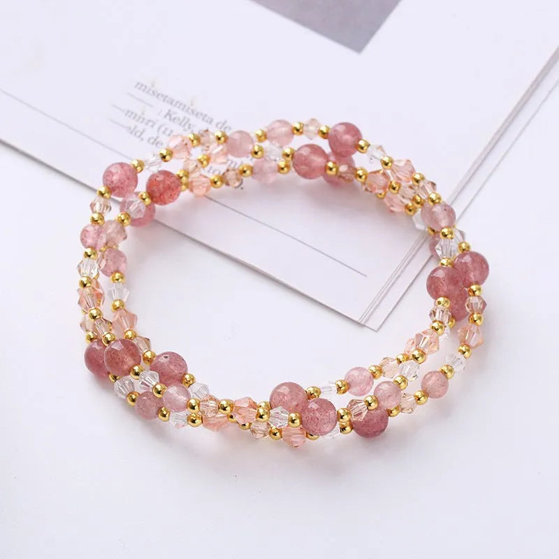Close-up of a women's hand-made three-ring crystal bracelet with colourful beads on an adjustable rope.