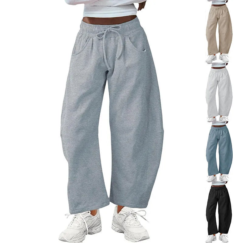 Women's loose grey cropped sweatpants with drawstring waist and side pockets on a hanger.
