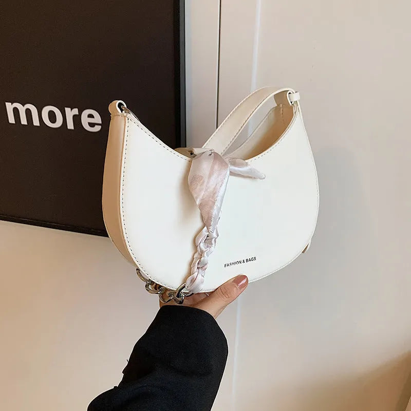 Small PU leather saddle bag on a flat surface, available in black, brown, coffee, green, khaki, and white