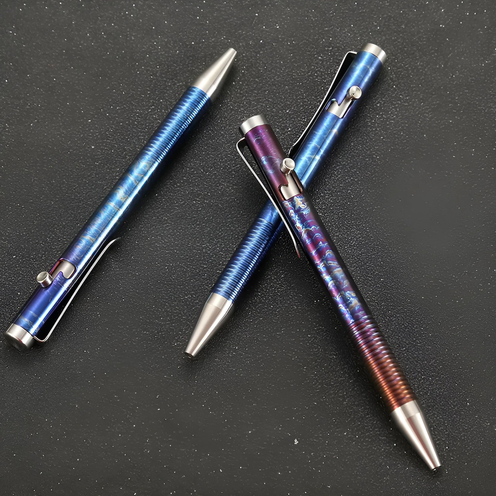 Titanium alloy gun bolt handle ball pen with a randomised phantom colour finish on a dark background.