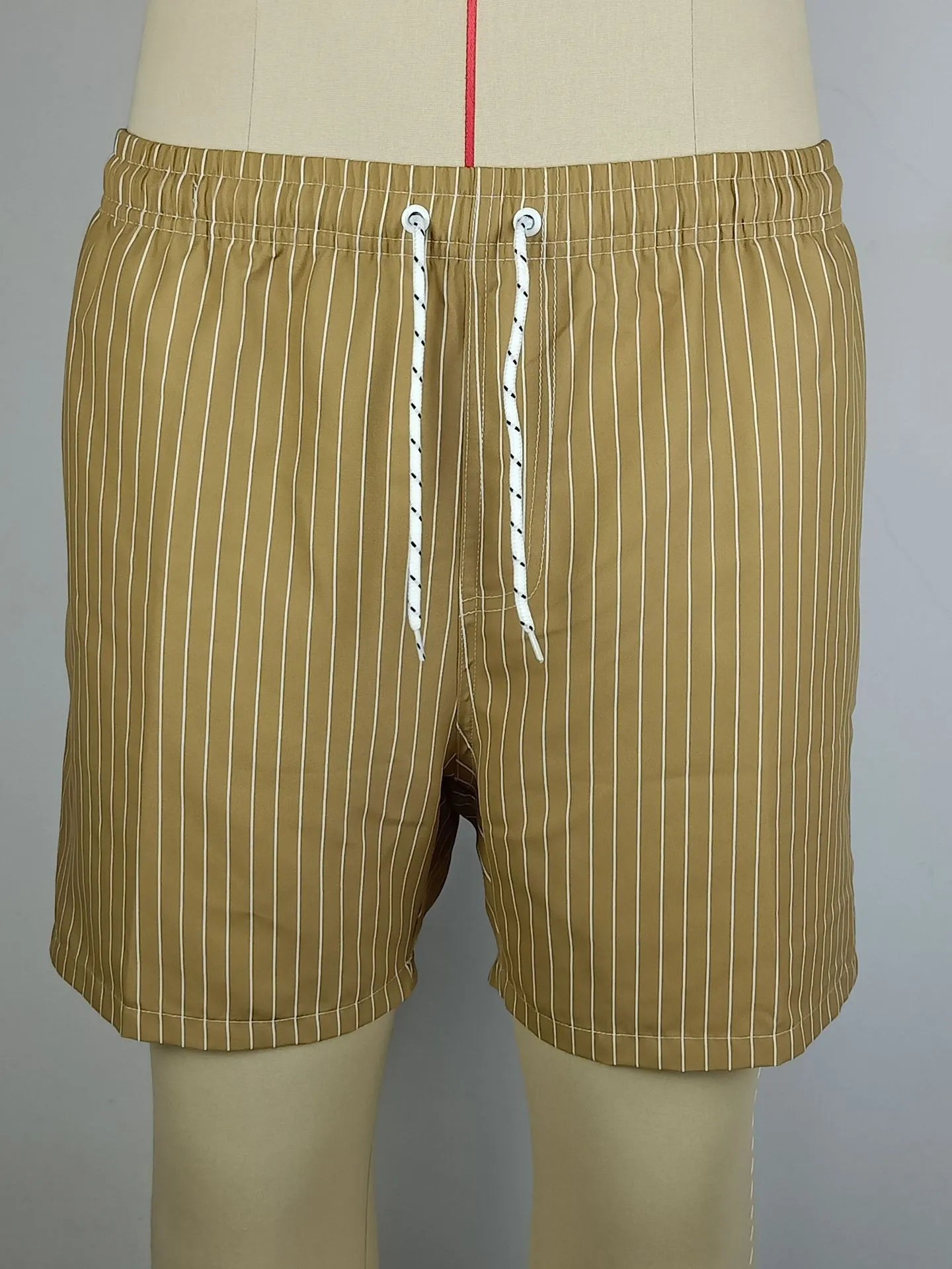 Navy blue and grey striped beach shorts with a straight leg opening on a mannequin.