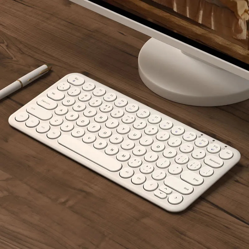 Ultra-thin white wireless keyboard and mouse set with USB receiver on a wooden desk.