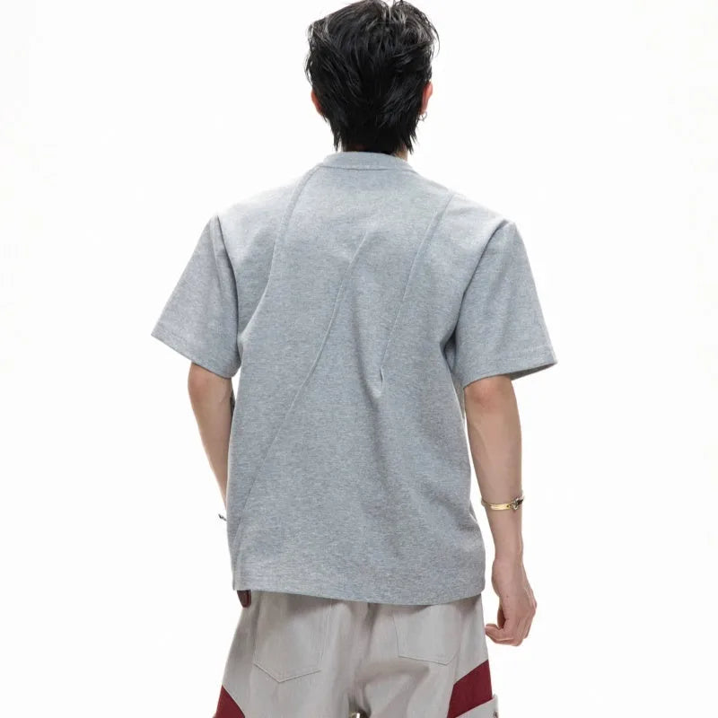 Men's grey cotton T-shirt with pleated detail on the front, showing a loose fit and round neck.