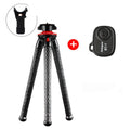 Black tripod octopus portable stand with flexible rubber legs, remote control, on a table with an iPhone