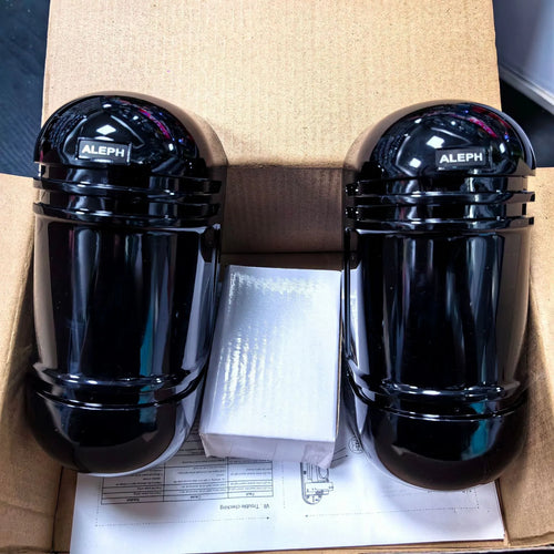 A pair of black wall-mounted infrared security detectors with wired terminals.