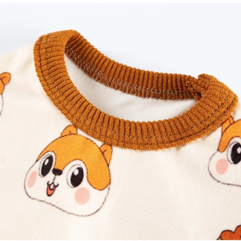Small dog wearing Chip 'n' Dale themed cream onesie with yellow trim and embroidered acorn pocket